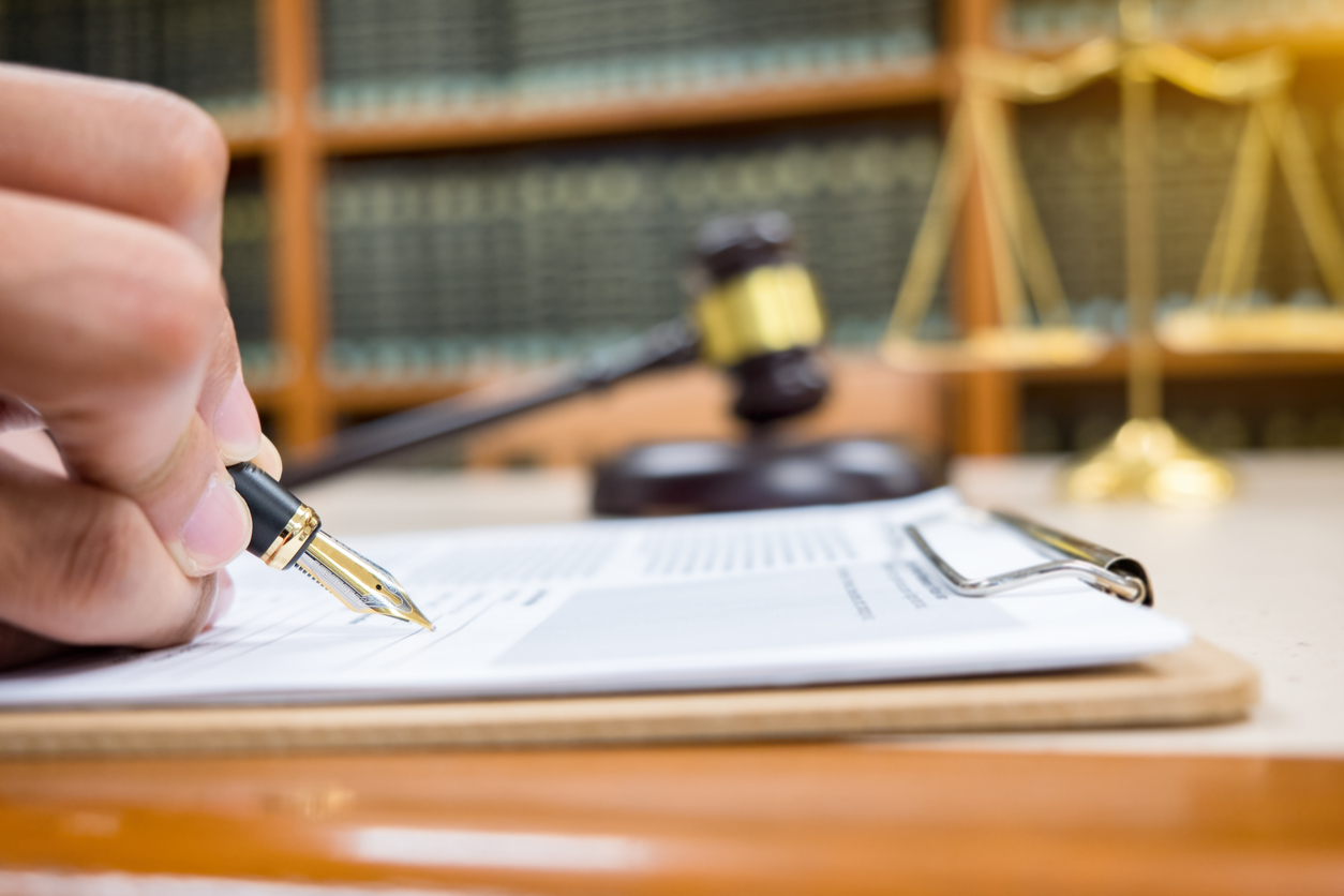 lawyer Detail of a judge sitting at his desk, studying new laws and legislation and taking notes. Selective focus