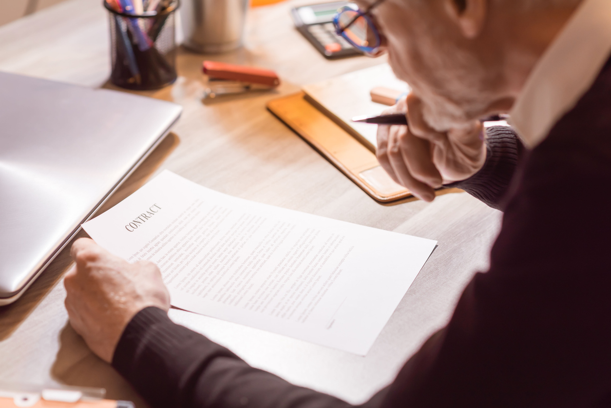 Senior businessman reviewing terms of contract at office