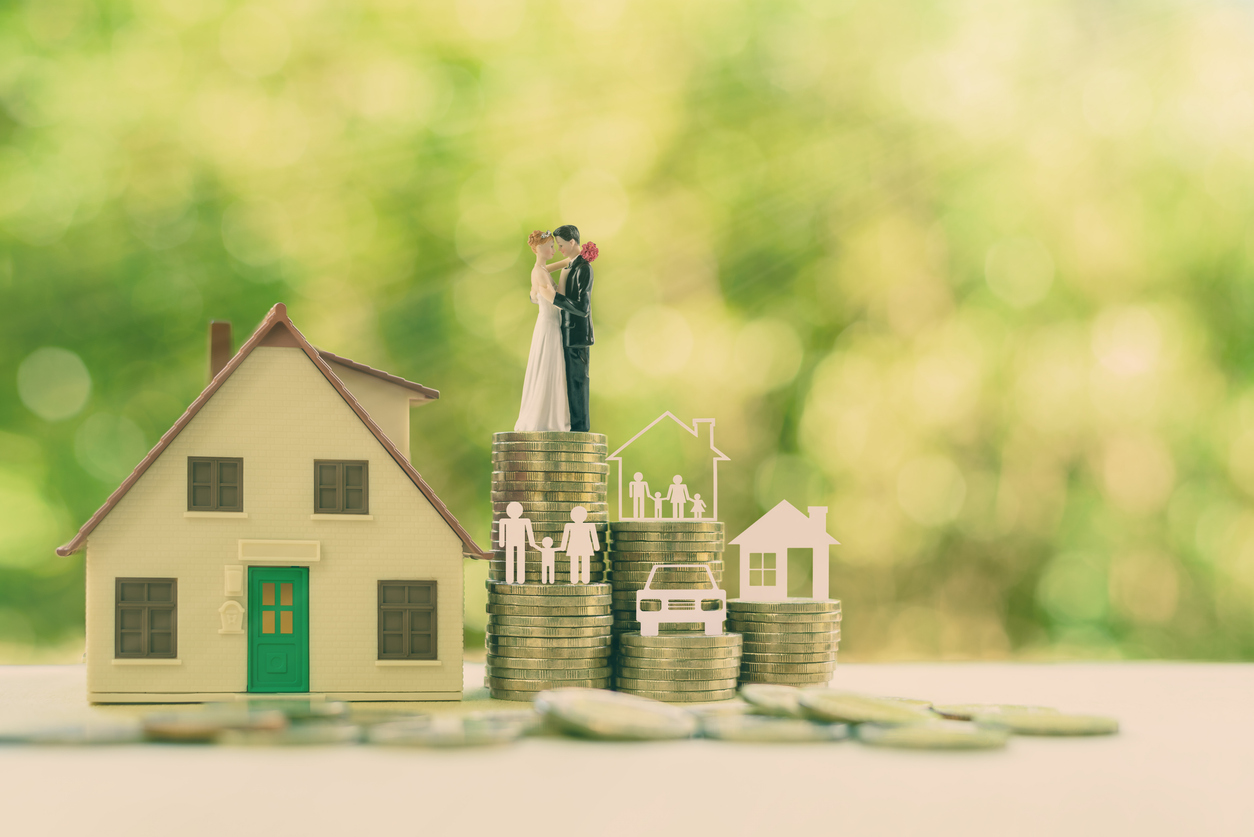 Miniature wedding couple, parent & child, a house or home, a car on rows of rising coins. The image depicting savings or growth for new family.