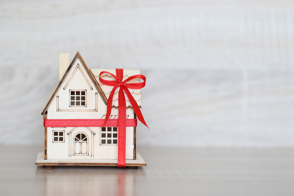 Real estate and Gift new home concept,Model house with Red ribbon on white background