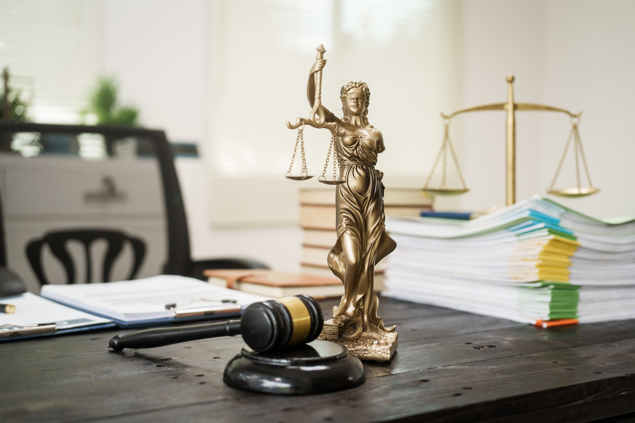 A lawyer's desk in the office is filled with legal documents.The lawyer provides consultations on civil criminal law,contract management, inheritance, notary public services,temporary bail requests.