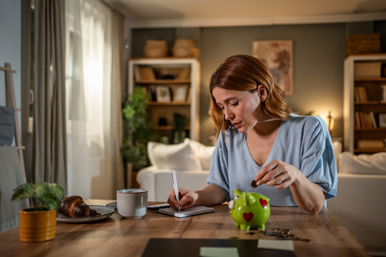 Woman managing home finances and savings with piggy bank