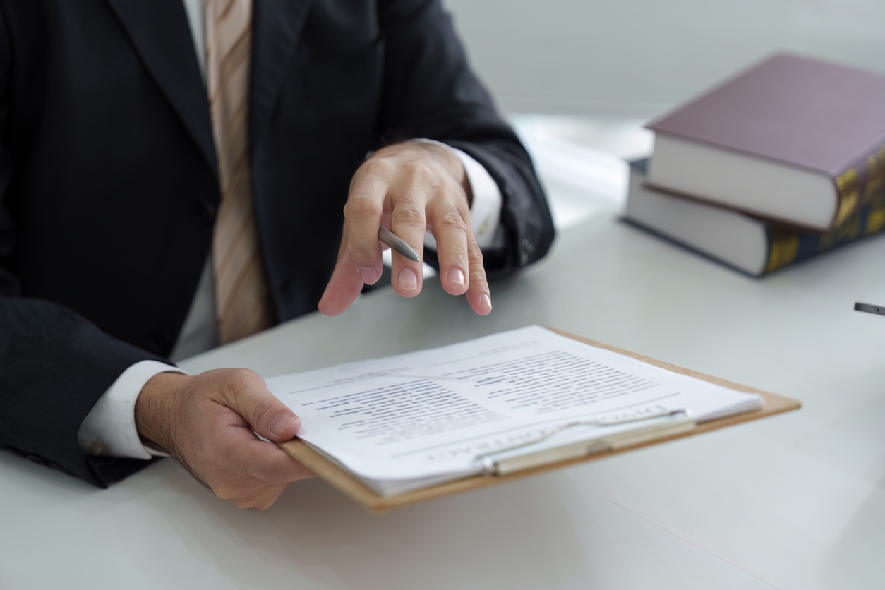 A focused lawyer explains important legal documents to a client, ensuring that all aspects are understood in the context of law and procedure.