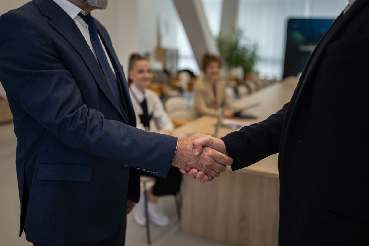 Business partners shaking hands making deal in office
