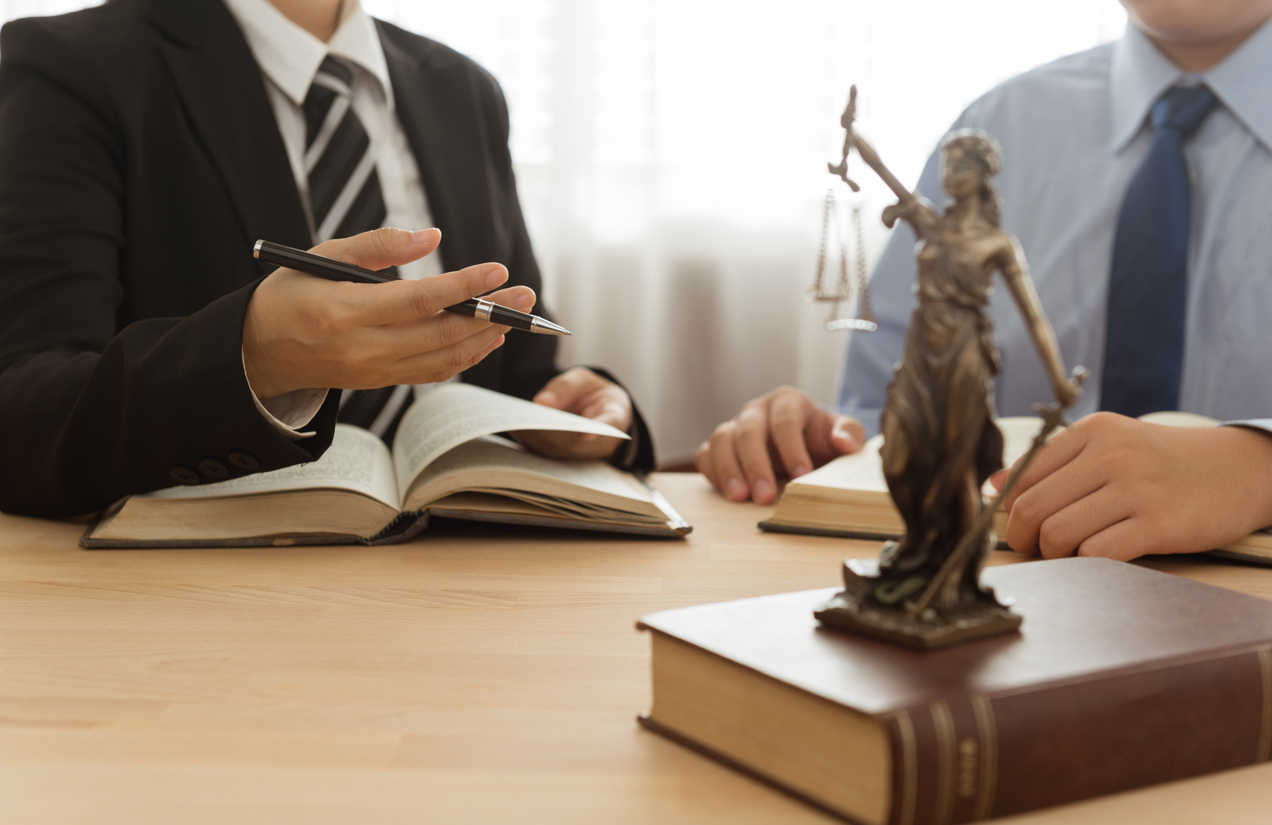 Law, Legal advice, Legislation concept. Lady justice on law book with lawyer and client in law office.