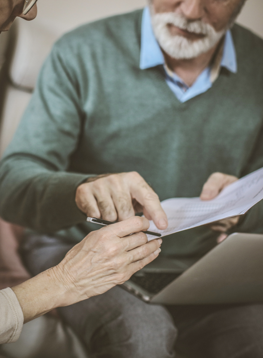 Senior couple at home with document and contractor.